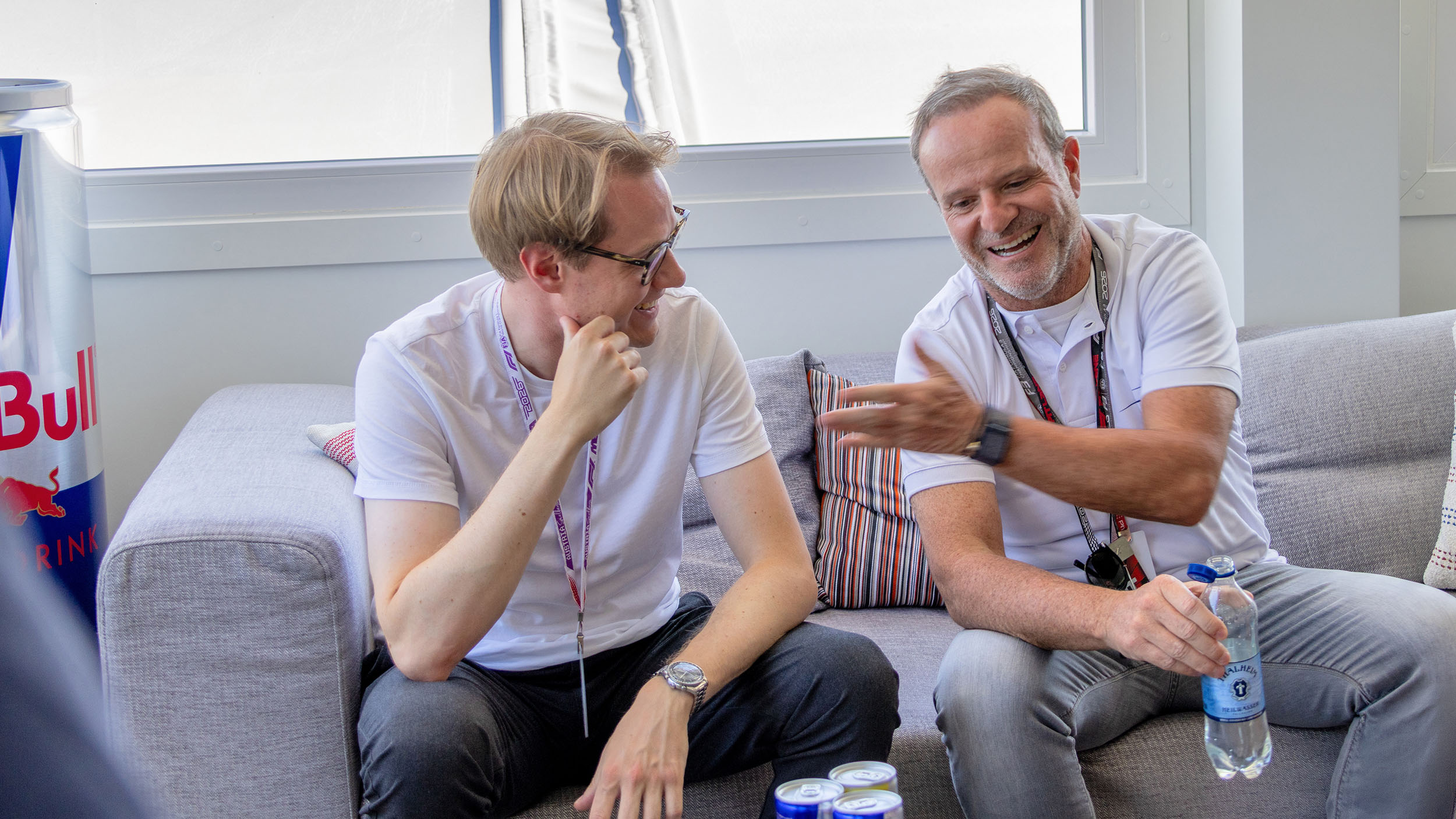Rubens Barrichello sitzt neben einem Journalisten auf einer Couch.