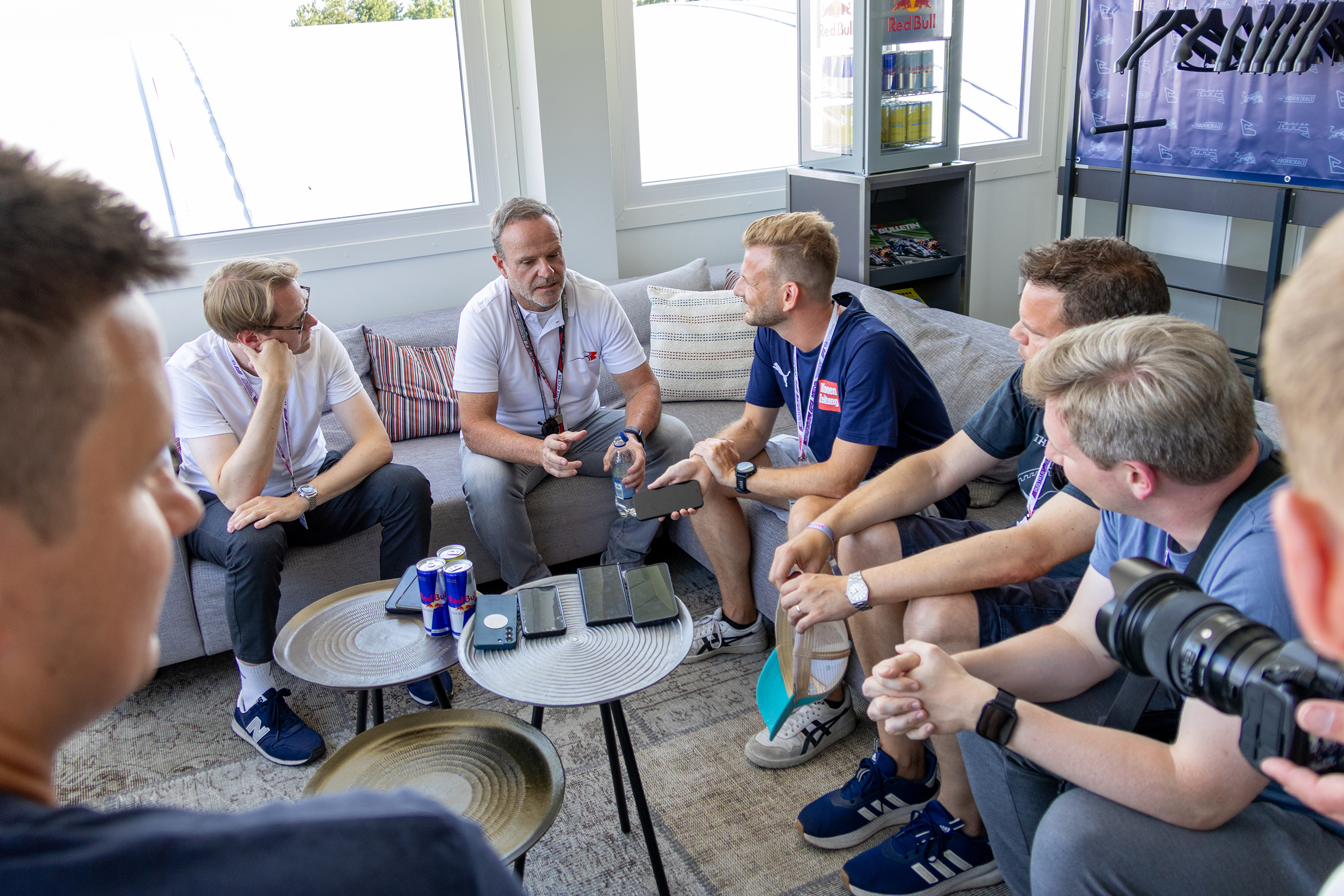 Rubens Barrichello sitzt auf der Couch. Um ihn herum sitzen Journalisten.