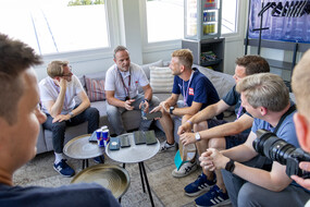 Rubens Barrichello sitzt auf der Couch. Um ihn herum sitzen Journalisten.