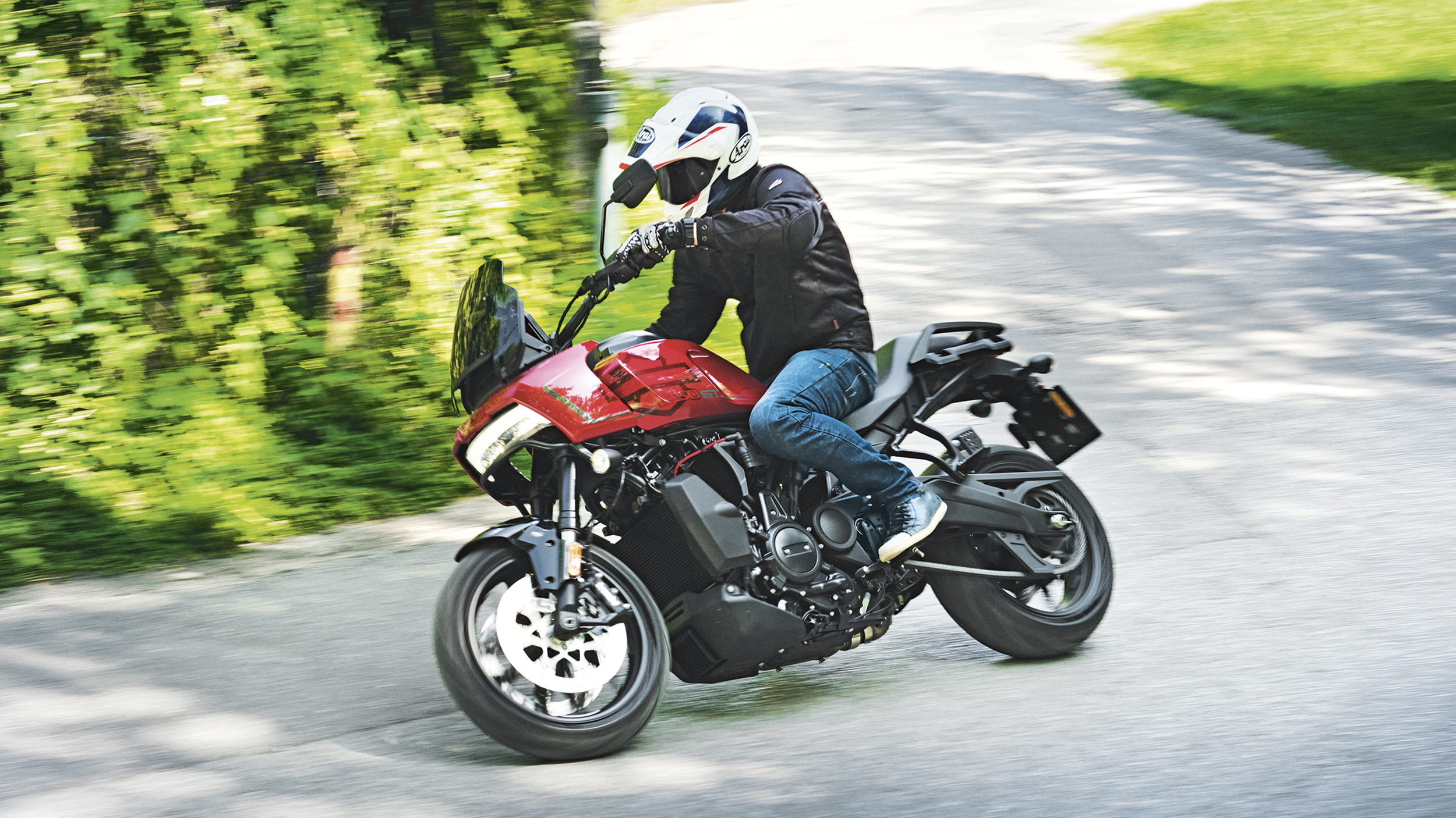 Ein Mann fährt auf einem rot-schwarzen Motorrad um eine Kurve.
