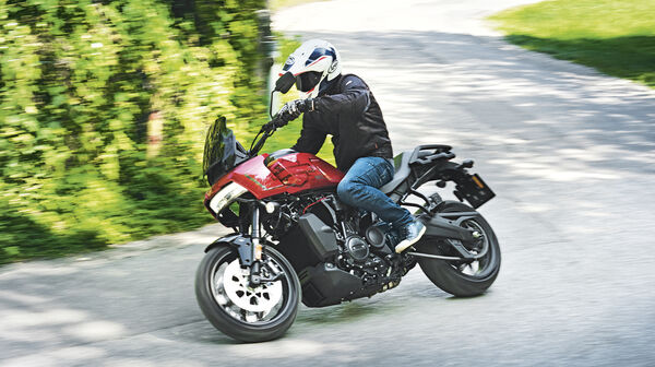 Ein Mann fährt auf einem rot-schwarzen Motorrad um eine Kurve.