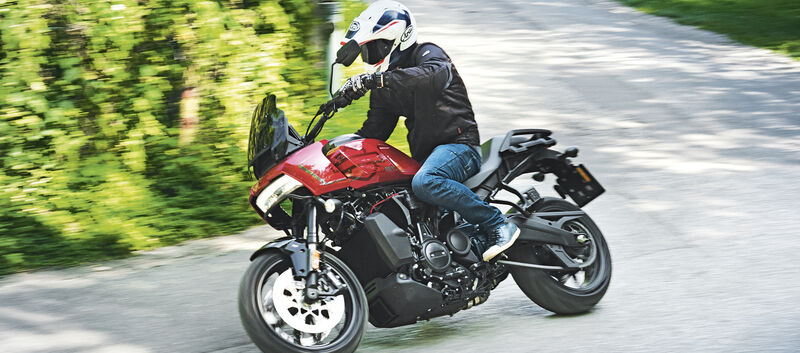 Ein Mann fährt auf einem rot-schwarzen Motorrad um eine Kurve.