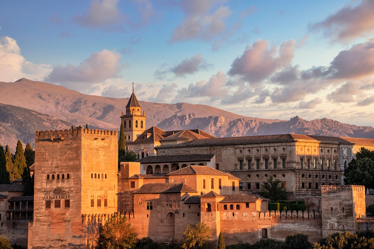 Das Foto zeigt die Alhambra in der Abendsonne vor den Gipfeln der Sierra Nevada.