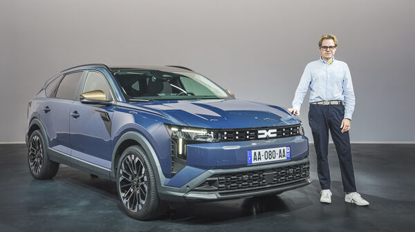 Einee Person im Hemd steht neben einem blauen Dacia Striker.