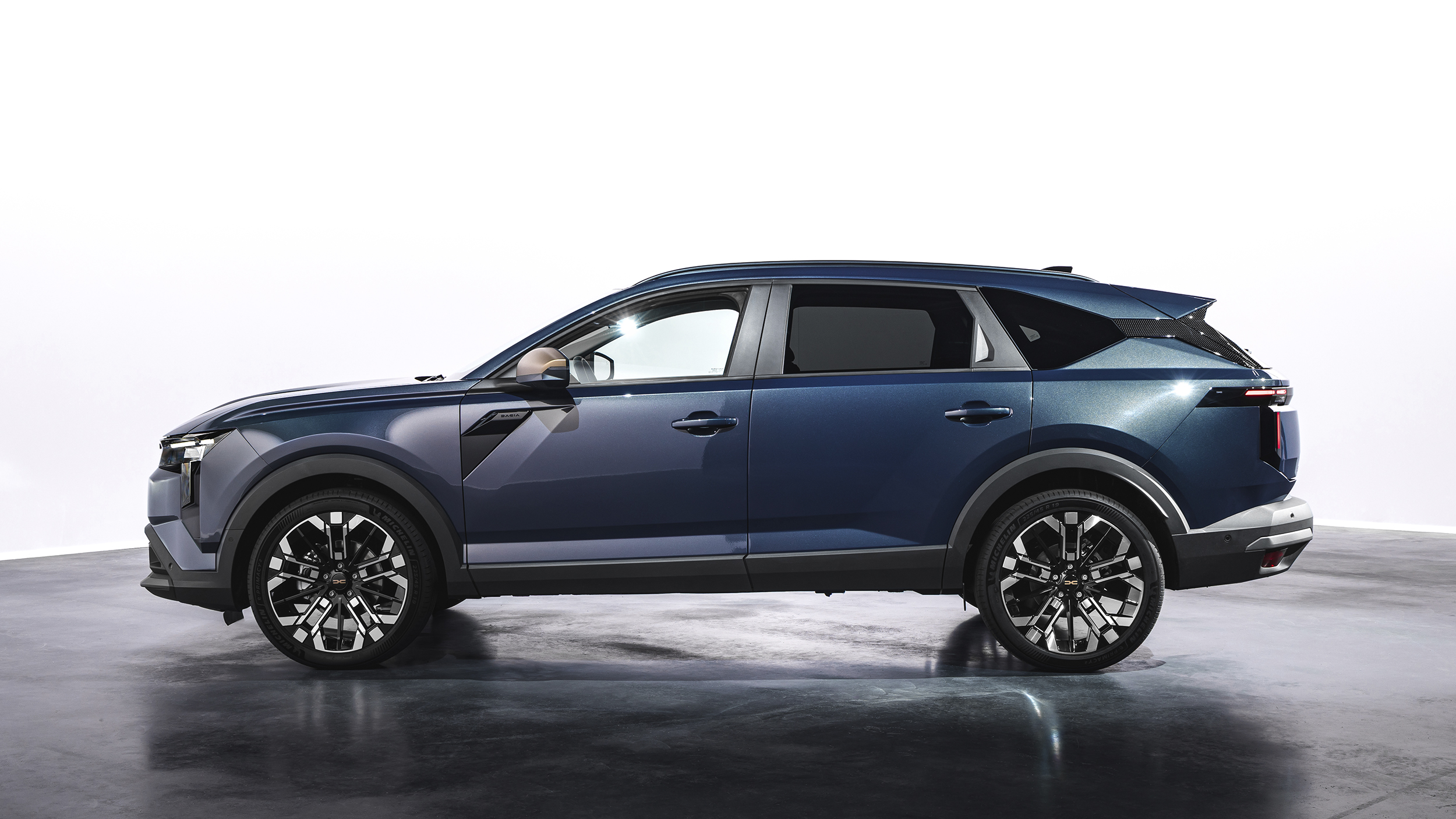 Seitenansicht eines blauen Dacia Striker, der in einem Studio steht.