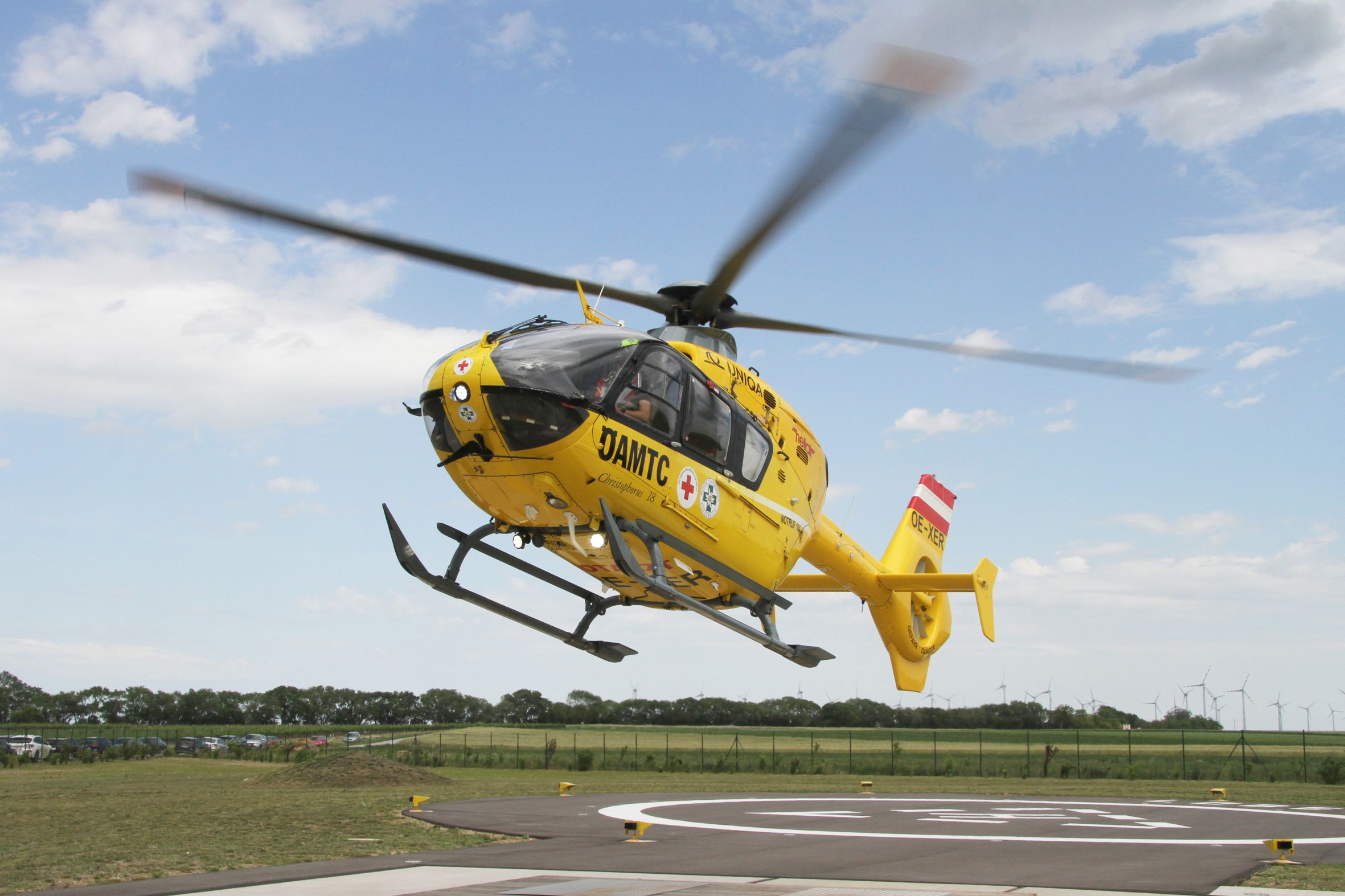 Ein gelber Notarzthubschrauber hebt von seinem Landeplatz aus ab