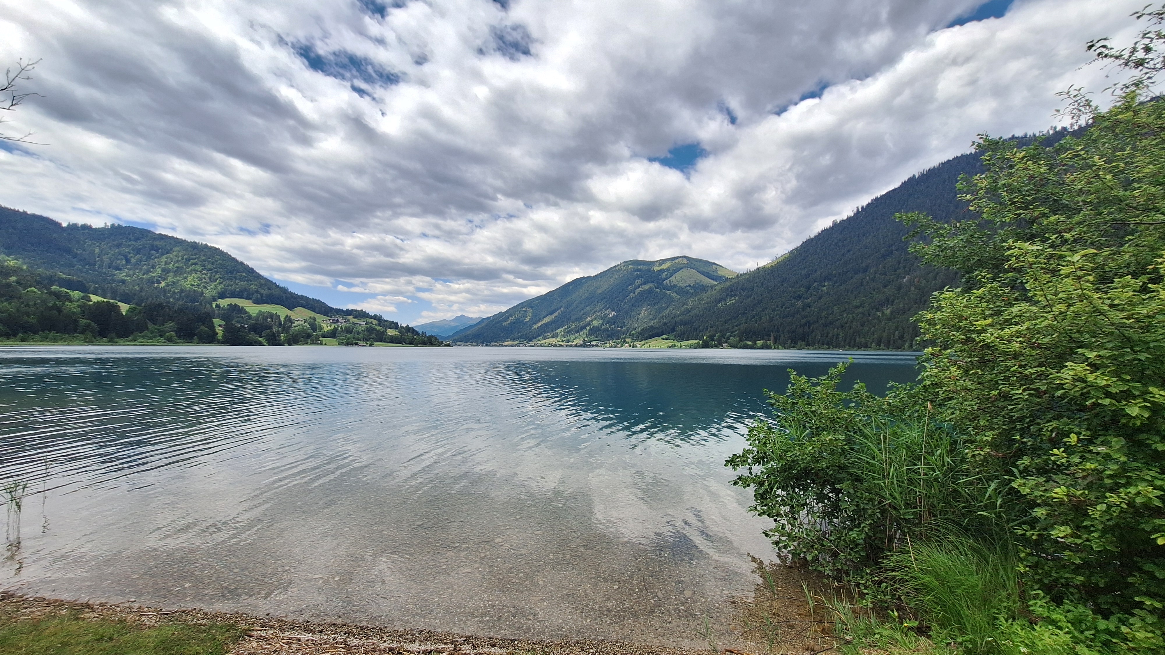 Das Foto zeigt den Weissensee - im Hintergrund sieht man Berge.