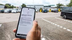 Man sieht ein Hand auf der eine Warnmeldung angezeigt wird, dass ein Insasse im Auto erkannt wurde.