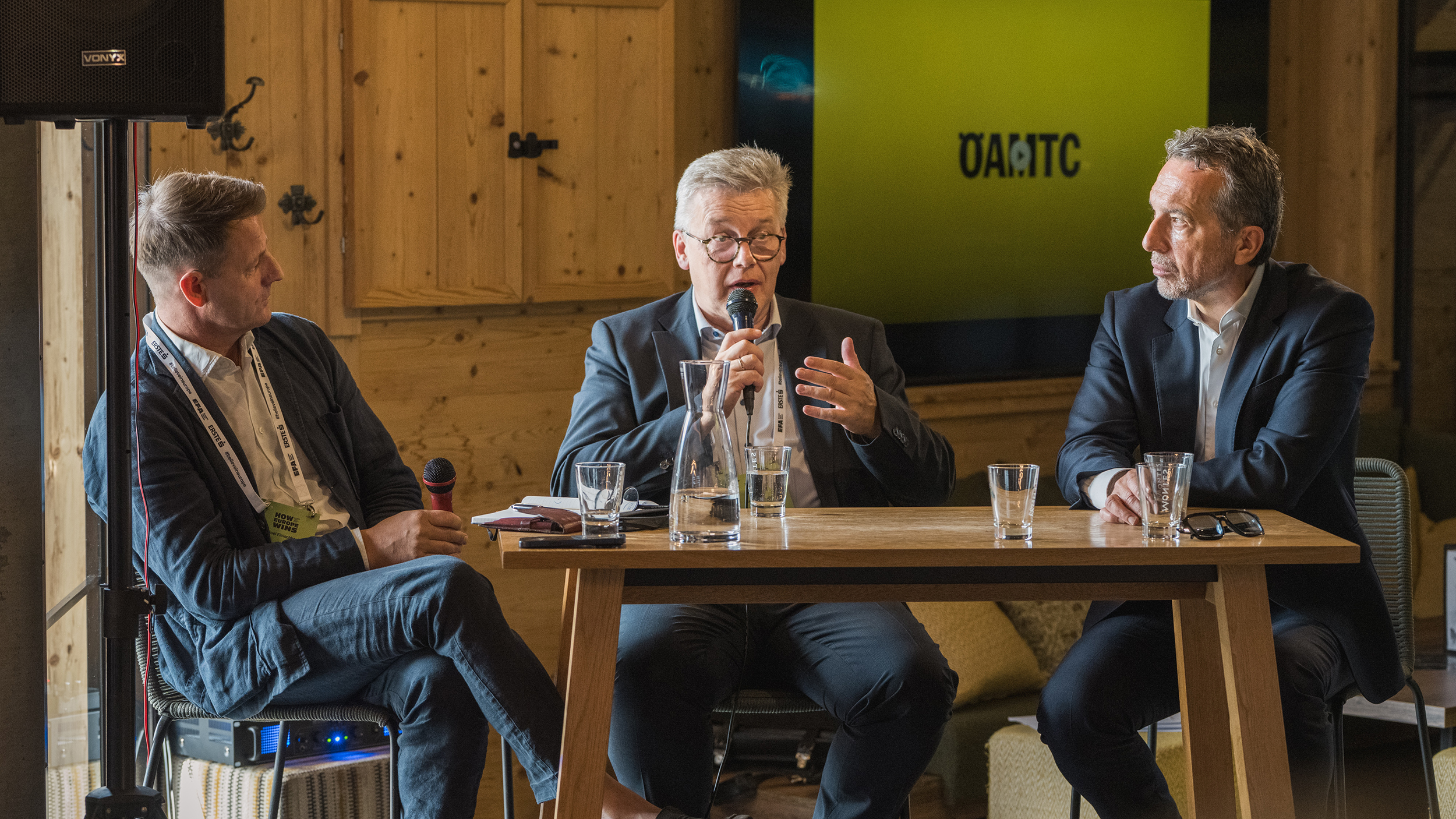 Drei Männer in Anzügen führen eine Diskussion