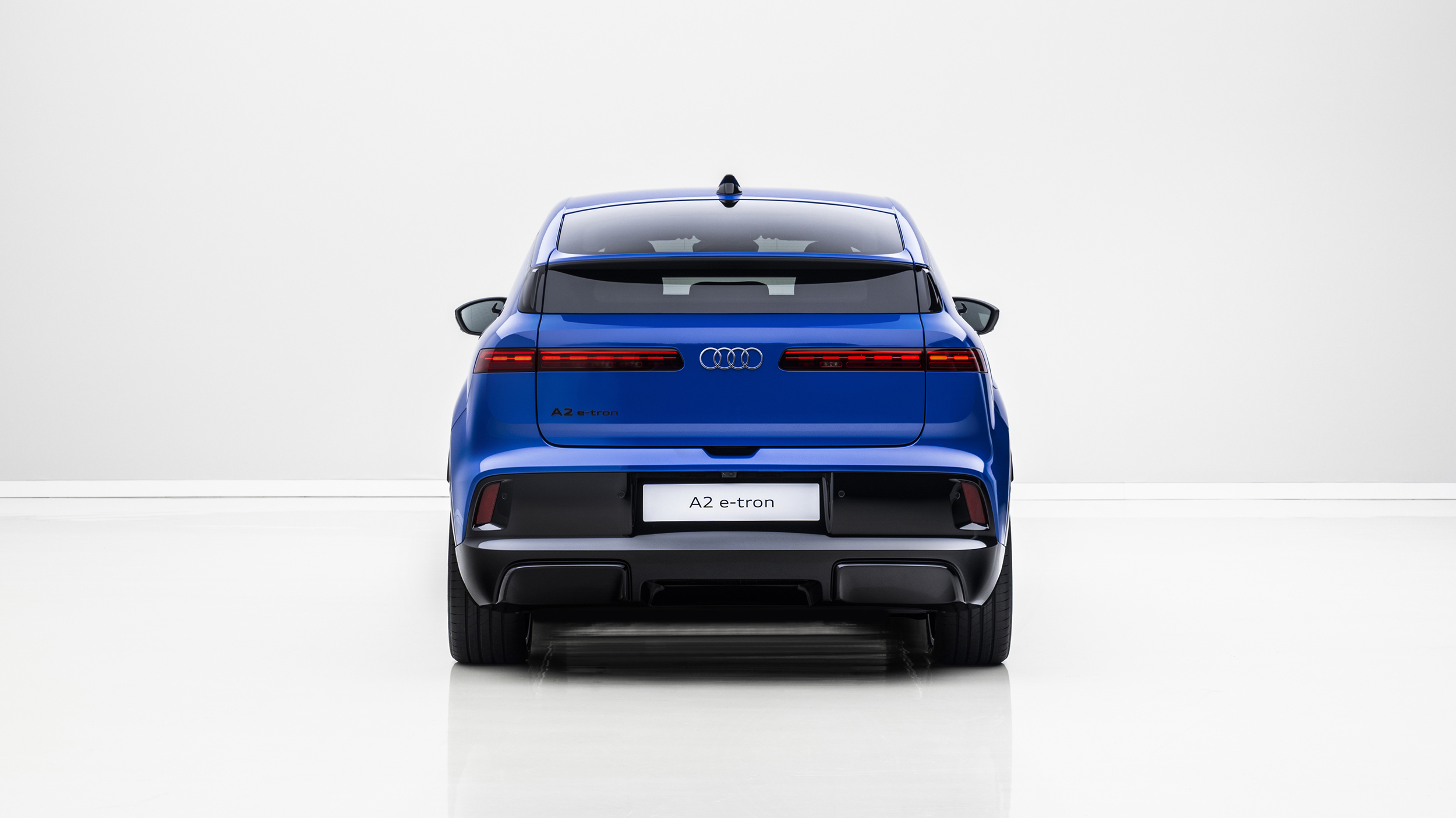 Das Heck eines blauen Audi A2 e-tron, der in einem weißen Studio steht.