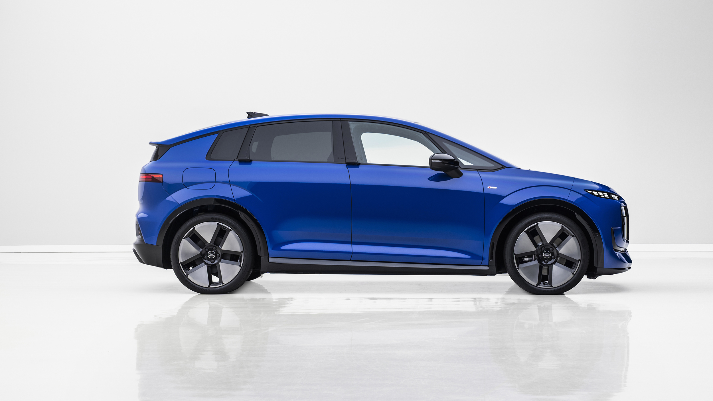 Seitenansicht eines blauen Audi A2 e-tron, der in einem weißen Studio steht. 