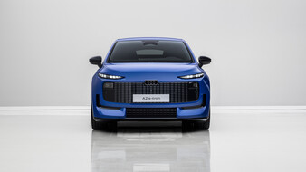Front eines blauen Audi A2 e-tron, der in einem weißen Studio steht.
