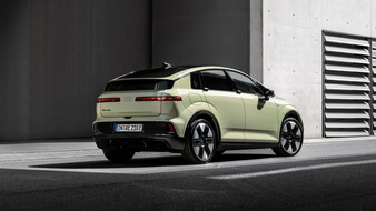 Heck eines gelben Audi A2 e-tron, der vor einem grauen Gebäude aus Beton steht.