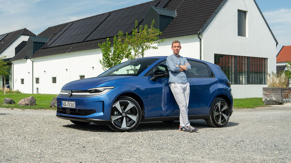 Ein Mann lehnt an einem blauen VW ID Polo.