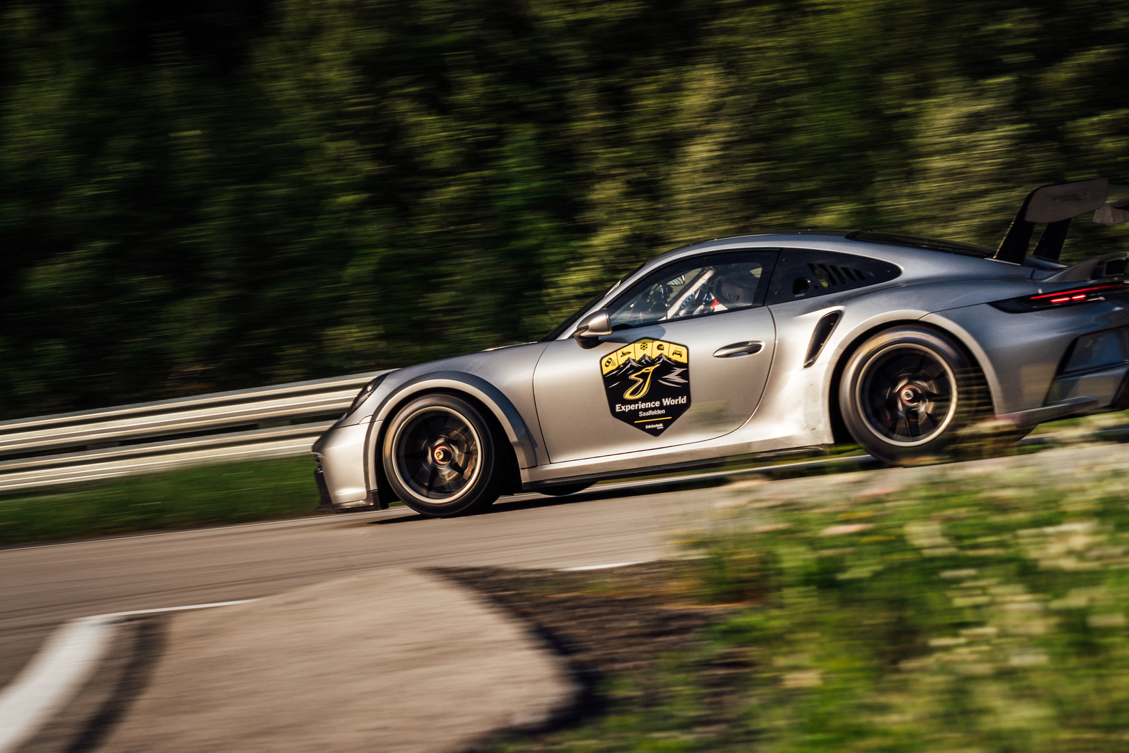 Im Bild eines auf der Strecke fahrenden Porsches mit dem Logo der Experience World Saalfelden