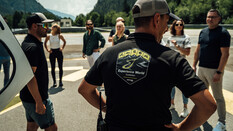 Man sieht einen Instruktor mit dem Logo der Experience World Saalfelden am Rücken, wie er zu einer Gruppe Teilnehmerinnen und Teilnehmern spricht