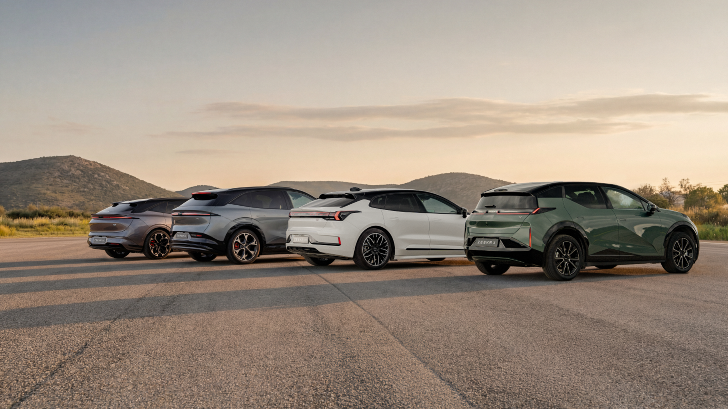 Vier Autos stehen auf einer großen Asphaltfläche.