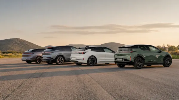Vier Autos stehen auf einer großen Asphaltfläche.