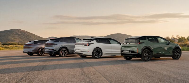 Vier Autos stehen auf einer großen Asphaltfläche.