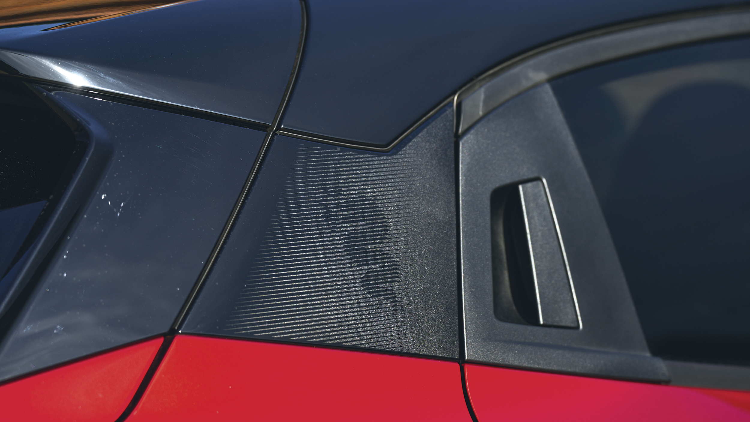 Detail der schwarzen C-Säule des Alfa Romeo Junior mit Alfa-Logo als Designelement.