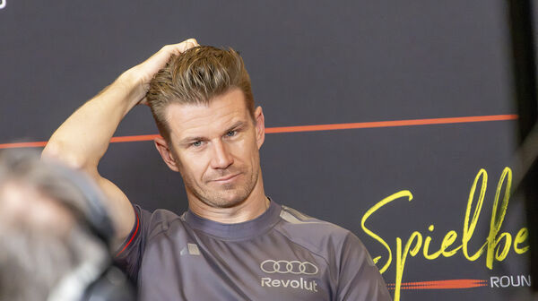 Nico Hülkenberg im grauen Audi-Revolut-Teamshirt fährt sich bei einer Pressekonferenz mit der linken Hand durch die Haare.