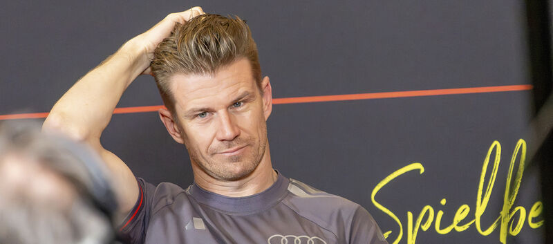 Nico Hülkenberg im grauen Audi-Revolut-Teamshirt fährt sich bei einer Pressekonferenz mit der linken Hand durch die Haare.