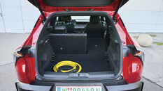 Offener Kofferraum des Alfa Romeo Junior Elettrica mit gelbem Ladekabel.