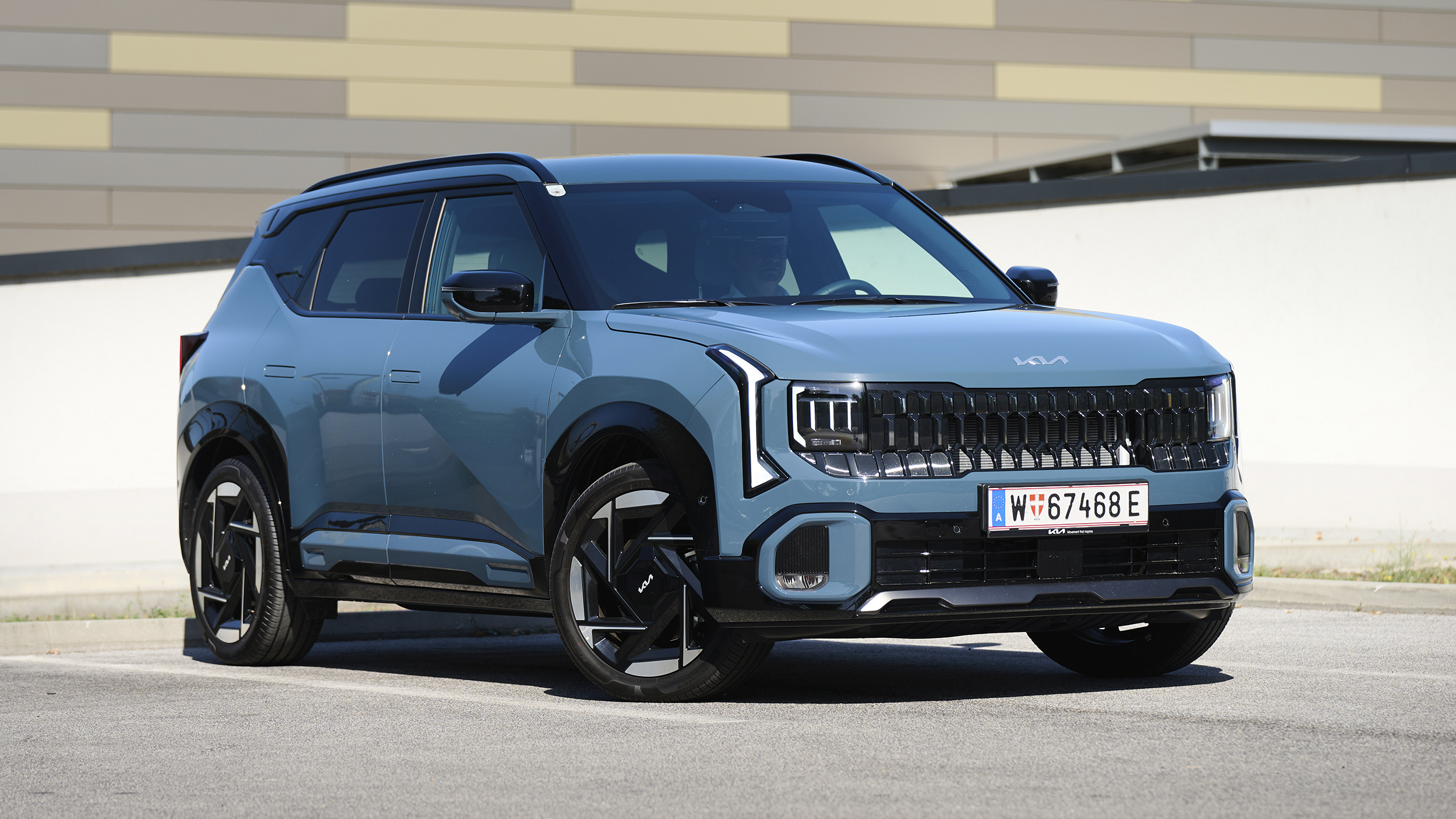 Kia Seltos in Blau aus schräger Frontansicht auf einem Parkplatz.