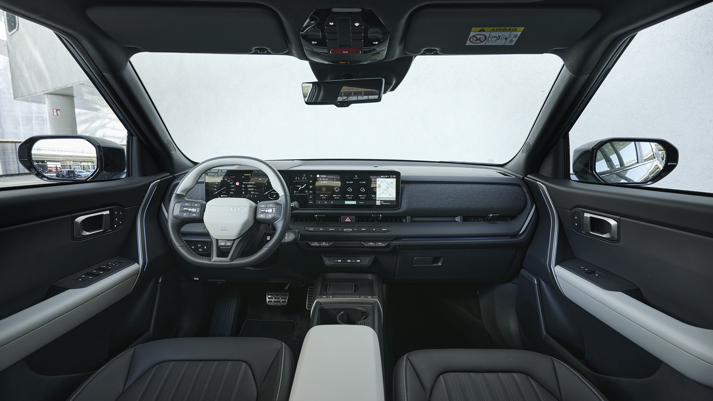 Blick durch den Innenraum des Kia Seltos auf Lenkrad, digitales Kombiinstrument, Zentraldisplay und Armaturenbrett.