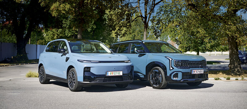 Zwei hellblaue SUV stehen nebeneinander auf einem Parkplatz; rechts ist ein Kia Seltos zu sehen, links ein Leapmotor B10.