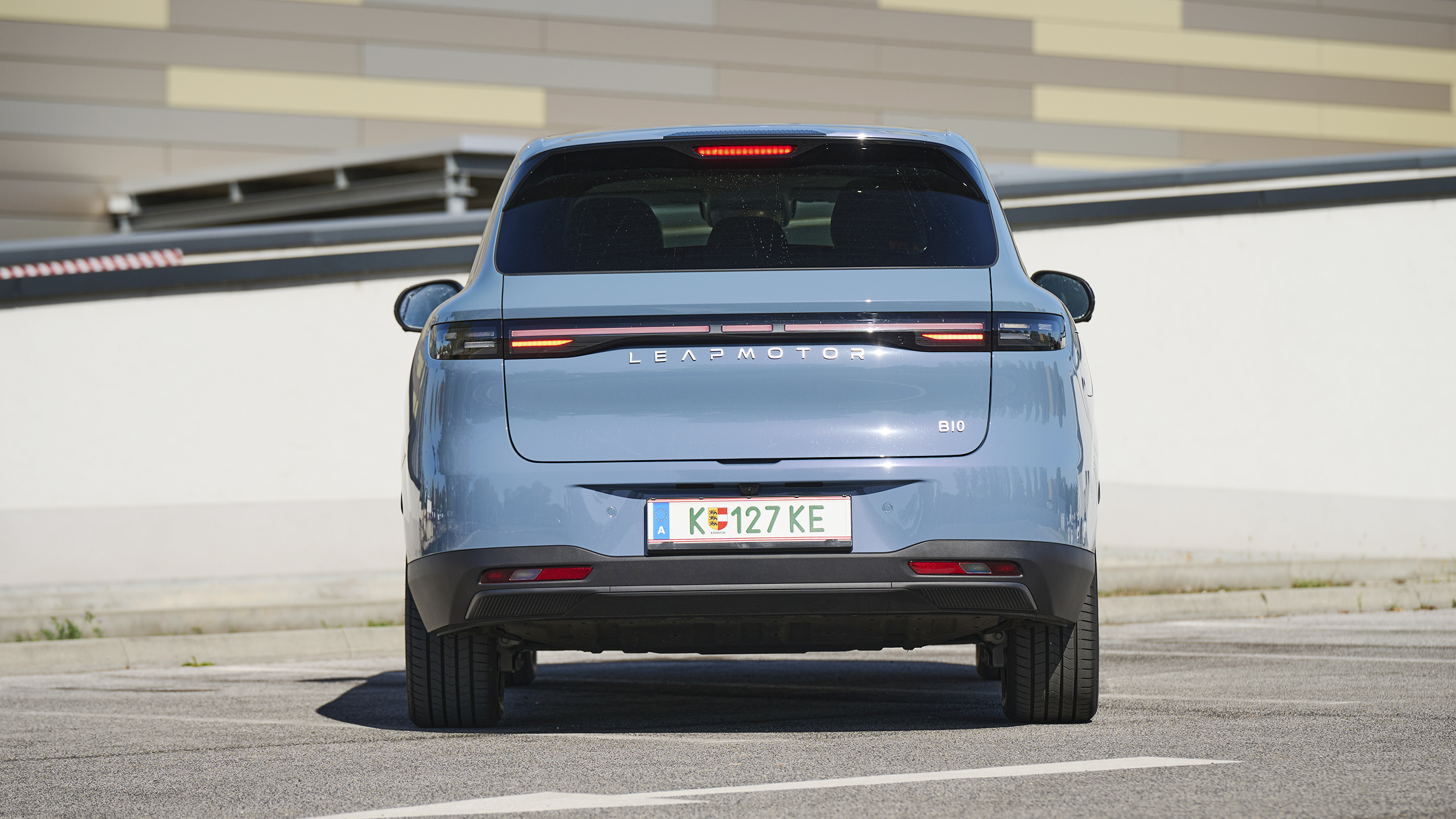 Heckansicht eines hellblauen Leapmotor B10 auf einem Parkplatz mit durchgehendem Rückleuchtenband und Leapmotor-Schriftzug.