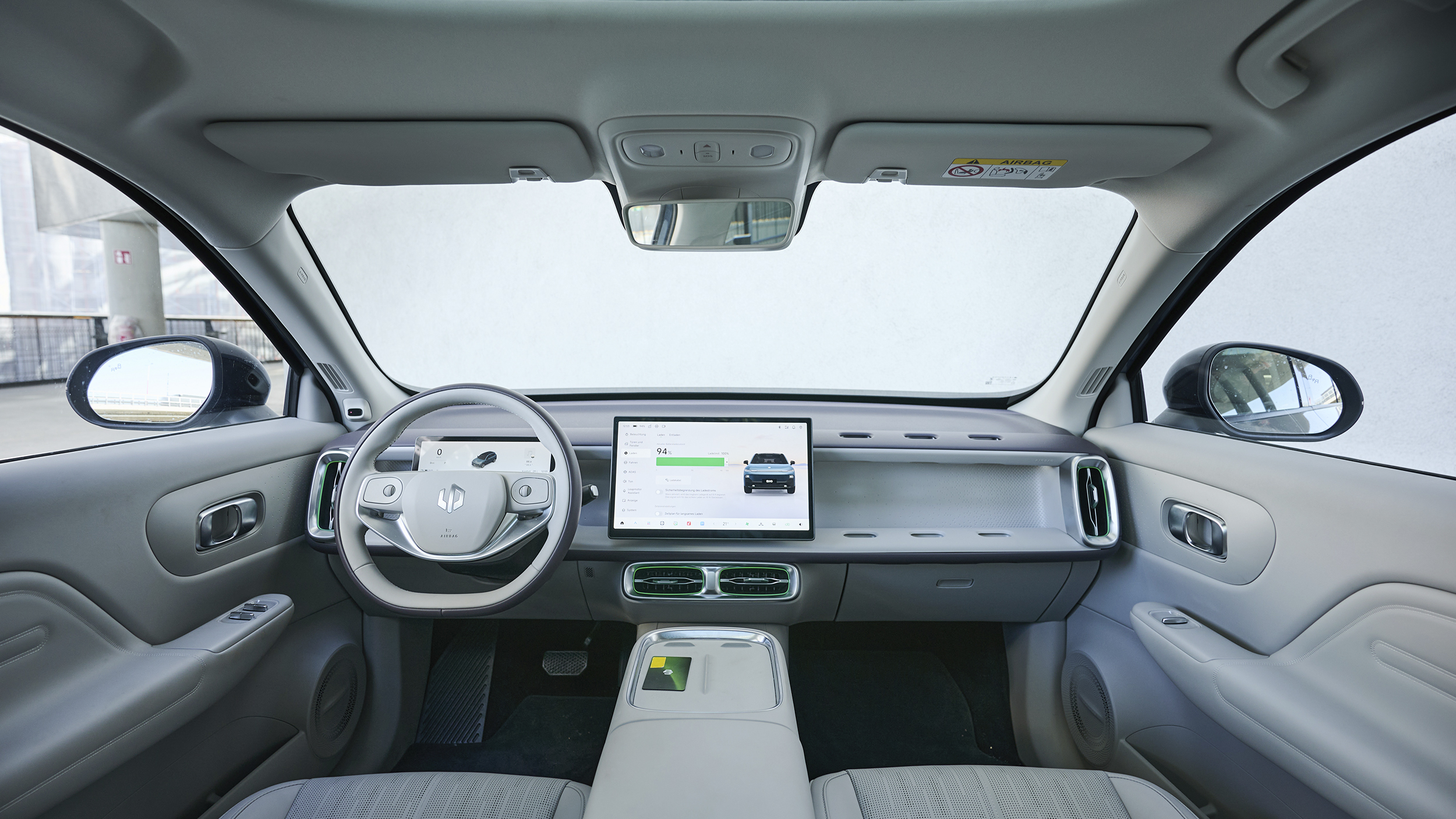 Weitwinkelansicht des vorderen Innenraums im Leapmotor B10 mit Lenkrad, zwei Displays, Mittelkonsole, Luftausströmern und Vordertüren.