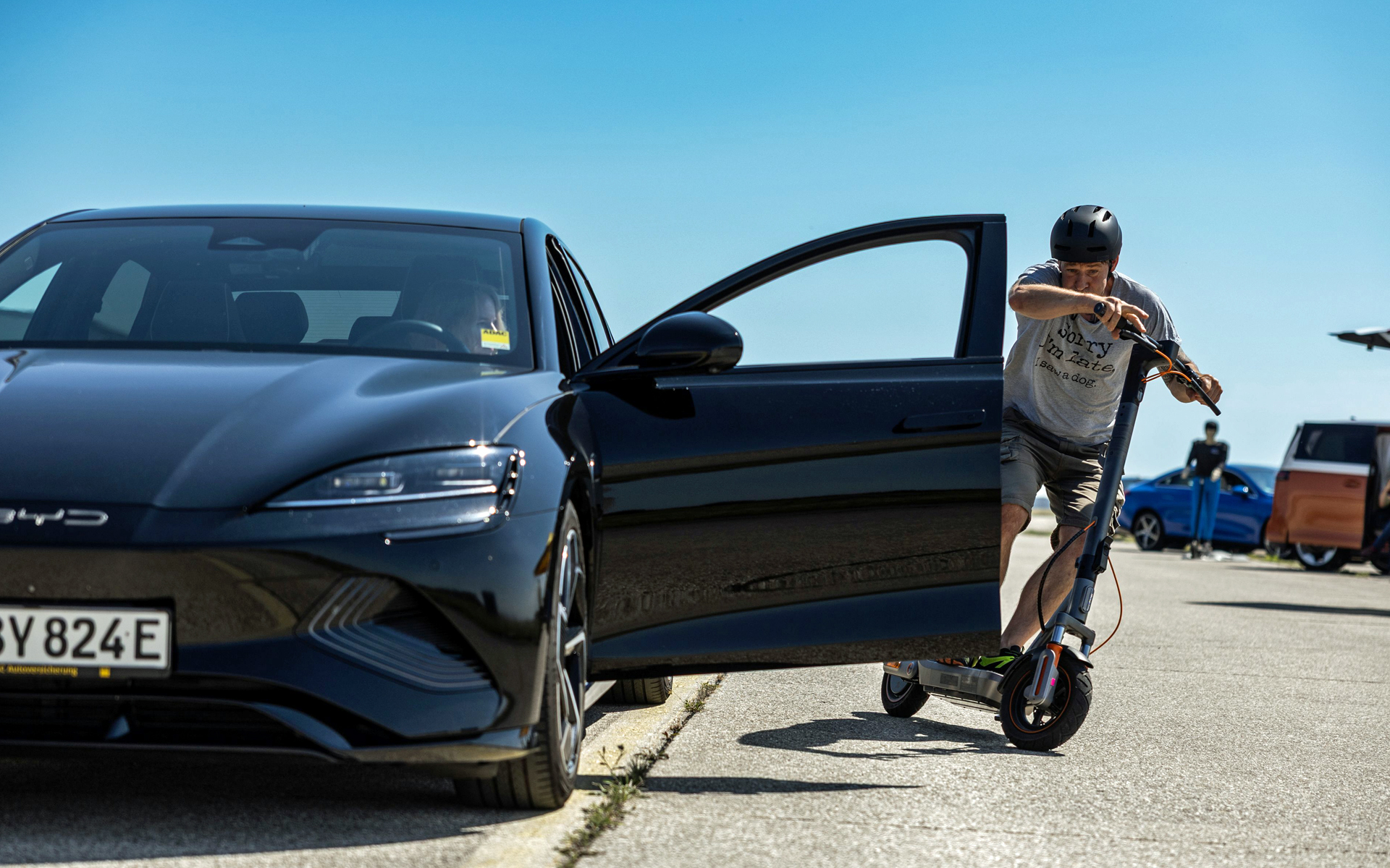 E-Scooter-Fahrer fährt knapp an geöffneter Autotür.