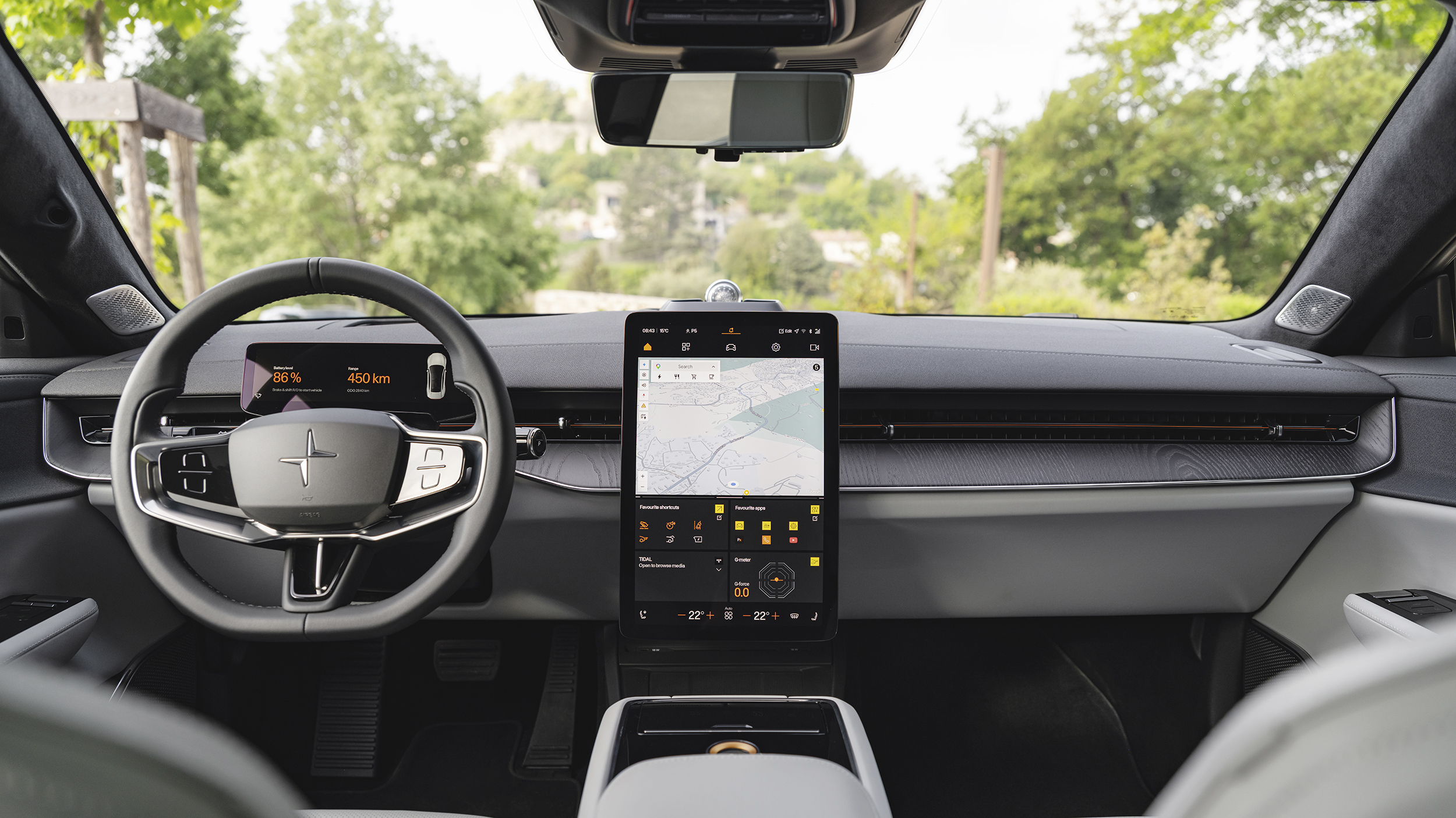Cockpit des Polestar 5 mit Lenkrad, digitalem Fahrerdisplay und zentralem Hochformat-Touchscreen mit Kartenansicht.