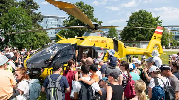 Besuchende stehen um den Notarzthubschrauber herum, nachdem er im Zuge der Veranstaltung gelandet ist.
