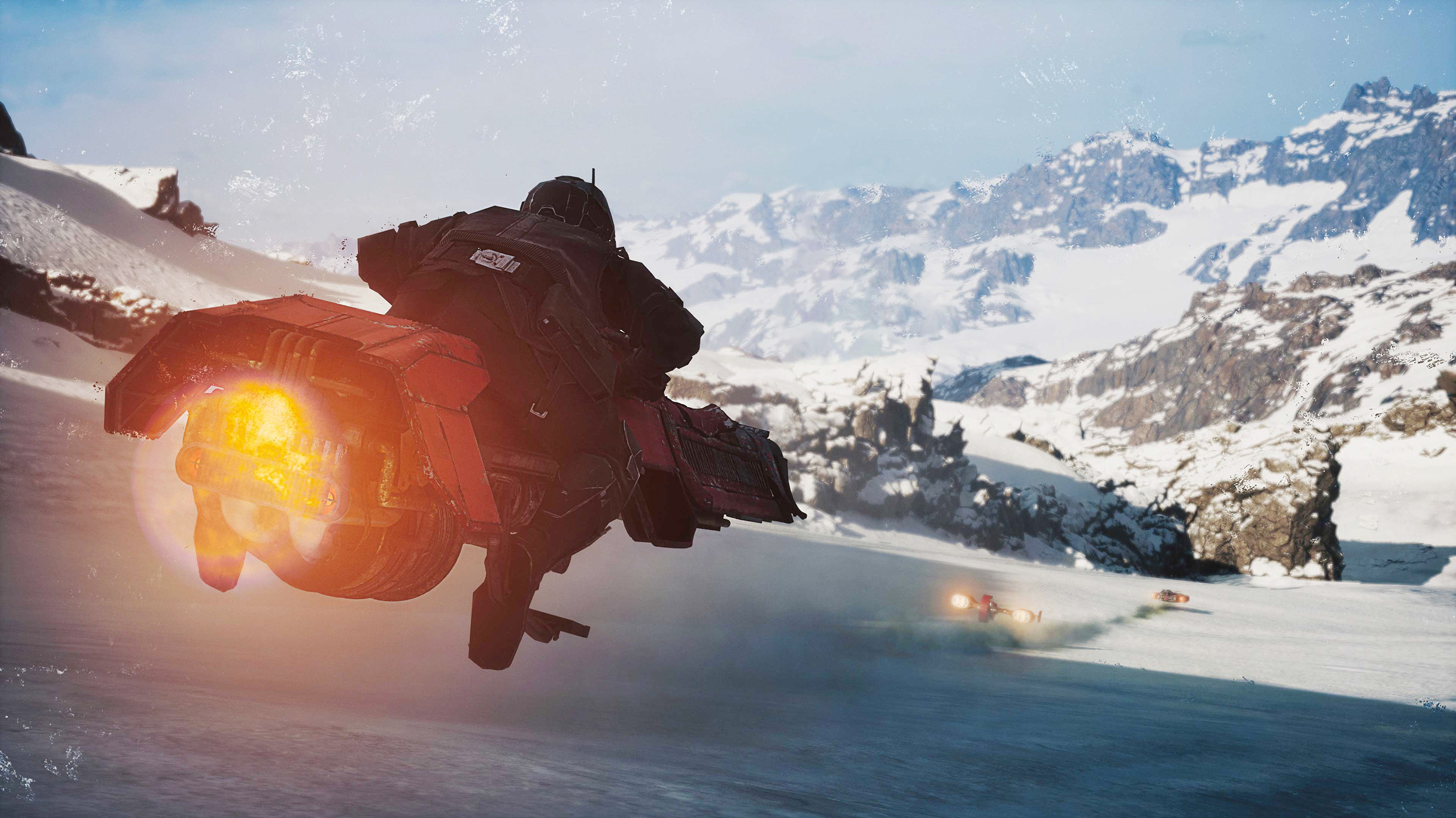 Ein dunkler, futuristischer Gleiter springt mit leuchtendem orangefarbenem Antrieb über eine verschneite Rennstrecke. Im Hintergrund sind schroffe, schneebedeckte Berge und weitere Fahrzeuge auf der Strecke zu sehen.