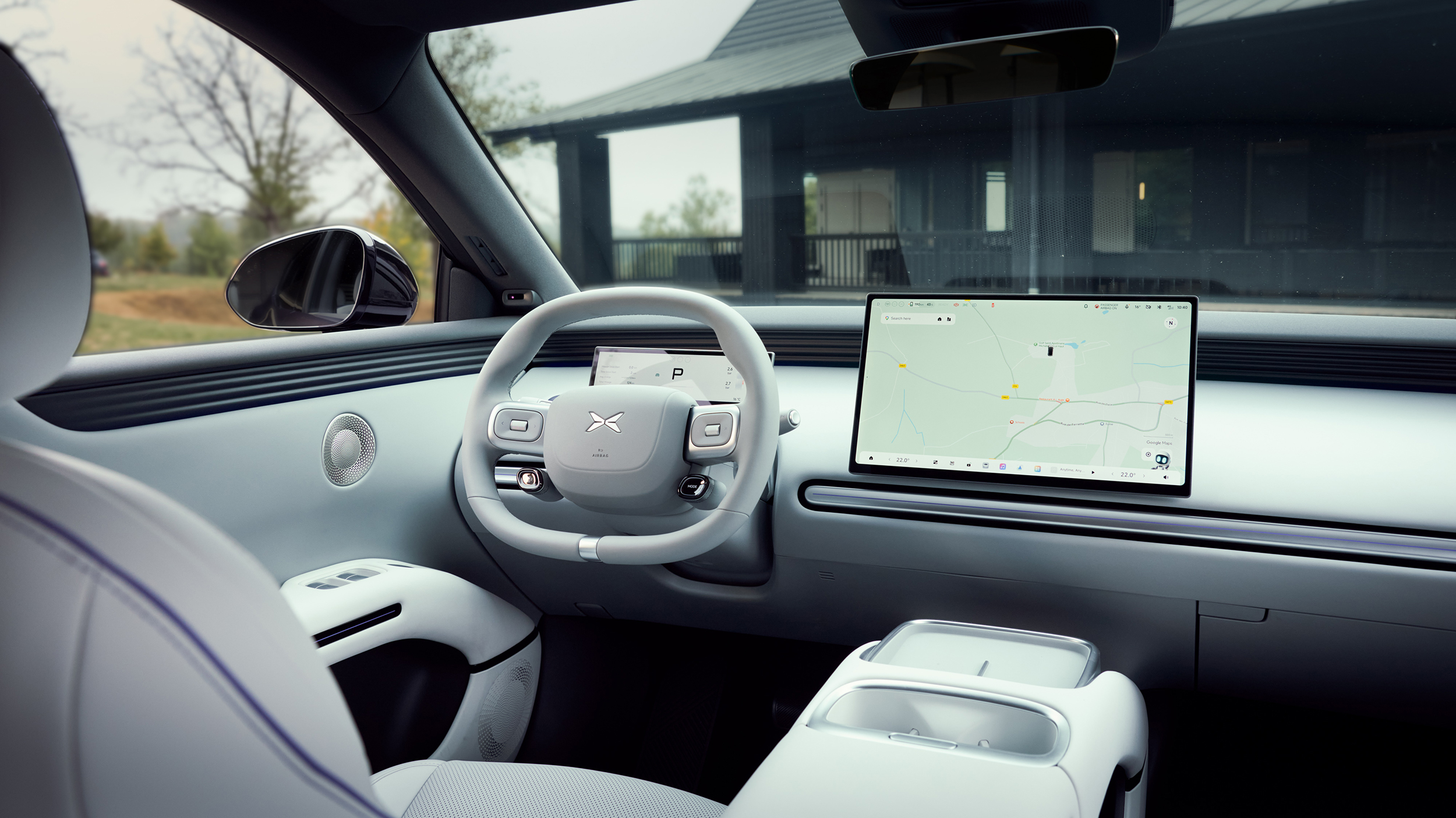 Helles Cockpit mit Multifunktionslenkrad, digitalem Instrumentendisplay, großem zentralem Bildschirm mit Kartenansicht und Ablagefächern in der Mittelkonsole.