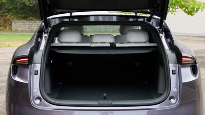 Geöffnete Heckklappe eines violetten SUV mit Blick auf den leeren, schwarz ausgekleideten Kofferraum, die Gepäckraumabdeckung und die aufrechten Rücksitzlehnen.