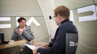 Dacia-CEO Katrin Adt im Gespräch mit einem Journalisten in einem Zelt.