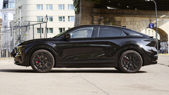 Silhouette einer schwarzen Alpine A390 GT, die unter einer Brücke in der Stadt steht.