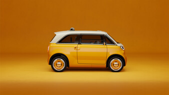 Orangefarbener Fiat Multiplina in der Seitenansicht mit weißem Dach, großen Seitenfenstern und orange-silbernen Radabdeckungen vor orangefarbenem Hintergrund.