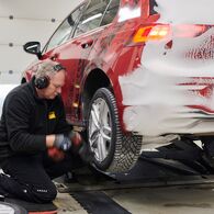 Techniker montieren Reifen an einem der Testfahrzeuge