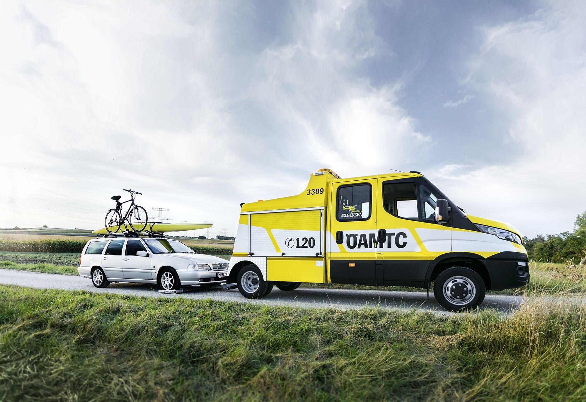 Ein ÖAMTC Pannenfahrzeug schleppt ein silbernes KFZ ab