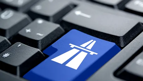 Computer-Tastatur mit blauer Taste und Autobahn-Symbol für den sicheren Online-Kauf einer Vignette