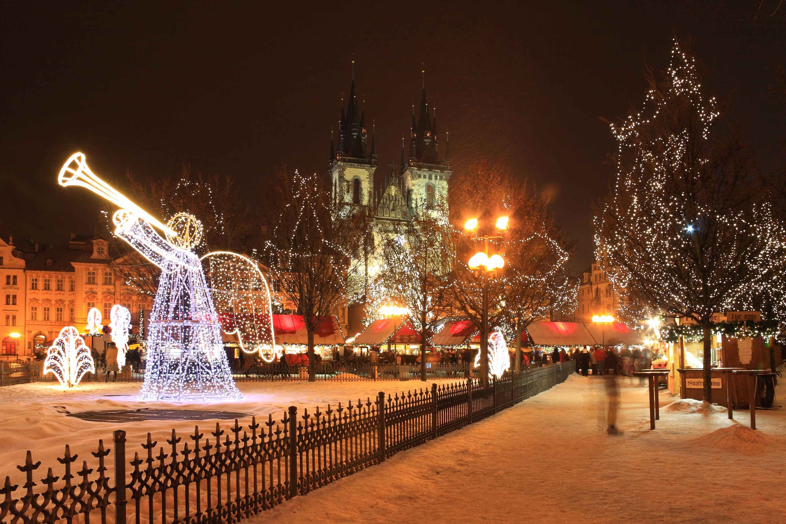 Ein weihnachtlich beleuchteter Platz mit einer Engel-Lichtskulptur, Schnee und Marktständen.
