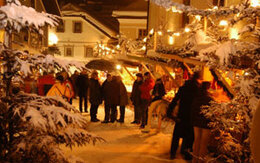 Winterlich verschneiter Adventmarkt mit weihnachtlicher Beleuchtung
