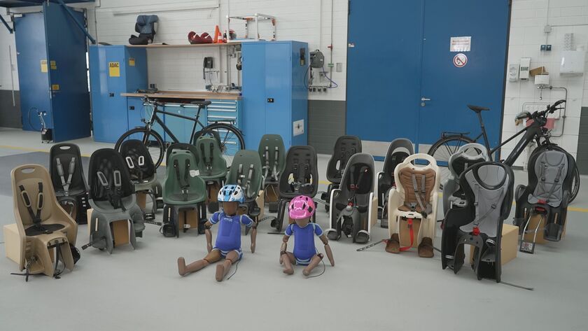 Aktuelle Fahrrad-Kindersitze im Test, aufgereiht in der Prüfhalle.