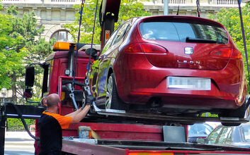 Autoabschleppung Ein Auto wird gerade abgeschleppt und wird auf das Abschleppfahrzeug geladen.