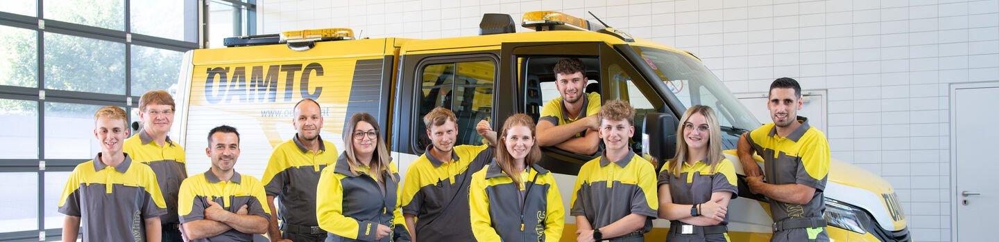 Die Kolleginnen und Kollegen vom Stützpunkt Bad Ischl stehen vor einem Pannenfahrzeug für ein Teamfoto.