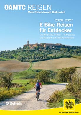 Belvelo 2026_2027.png Ein Radfahrer auf einer Schotterstraße in einer hügeligen Landschaft